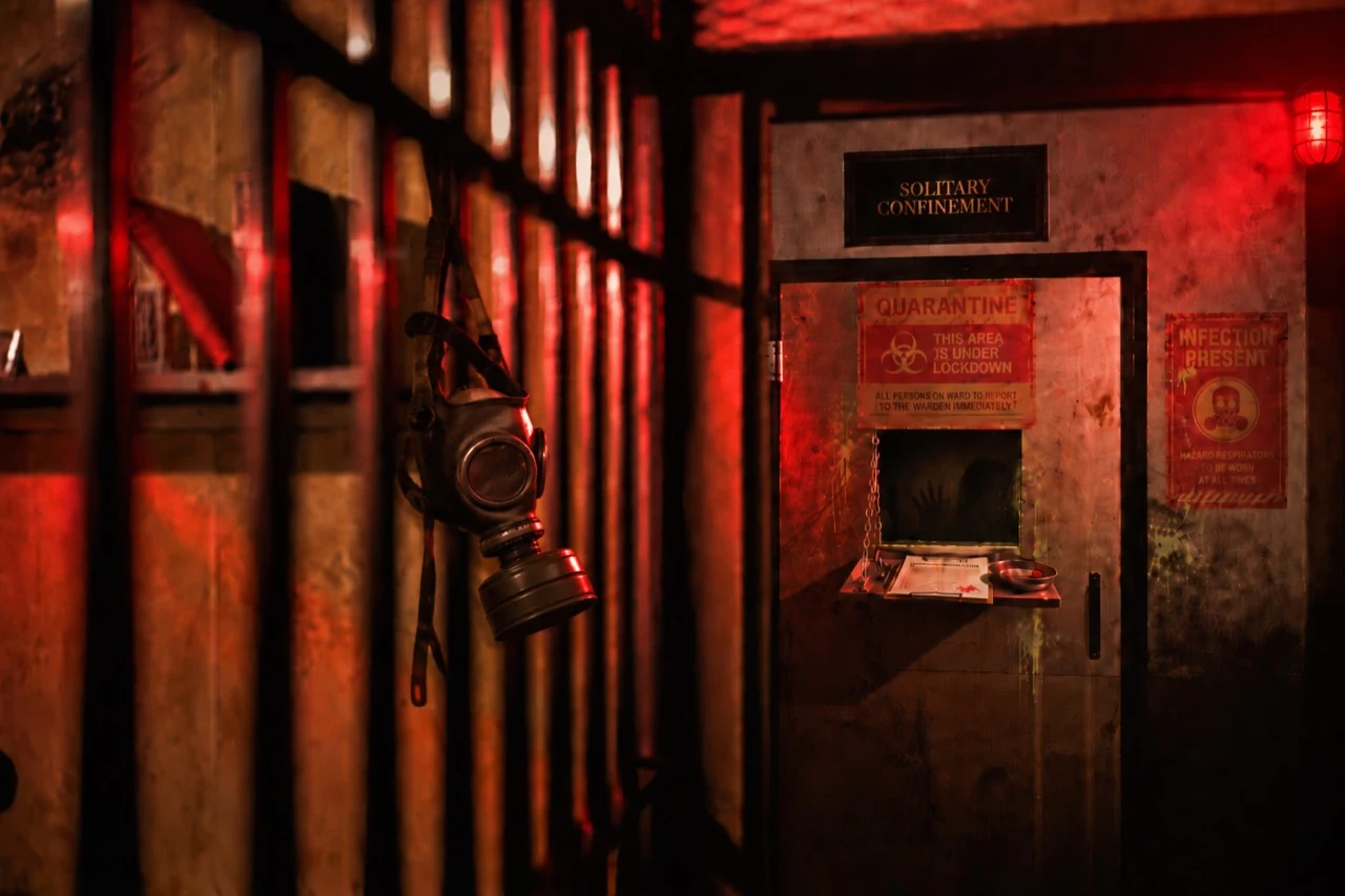 The red-lit solitary confinement door marked with quarantine and infection warnings